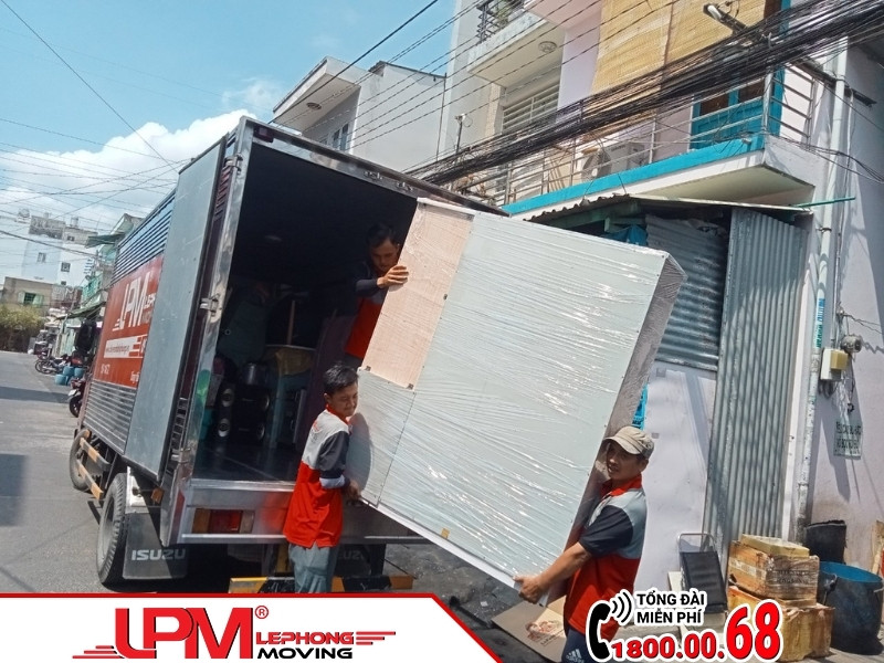 Hình ảnh đội ngũ LephongMoving đang khiêng tủ quần áo lớn tại dự án chuyển nhà Hóc Môn